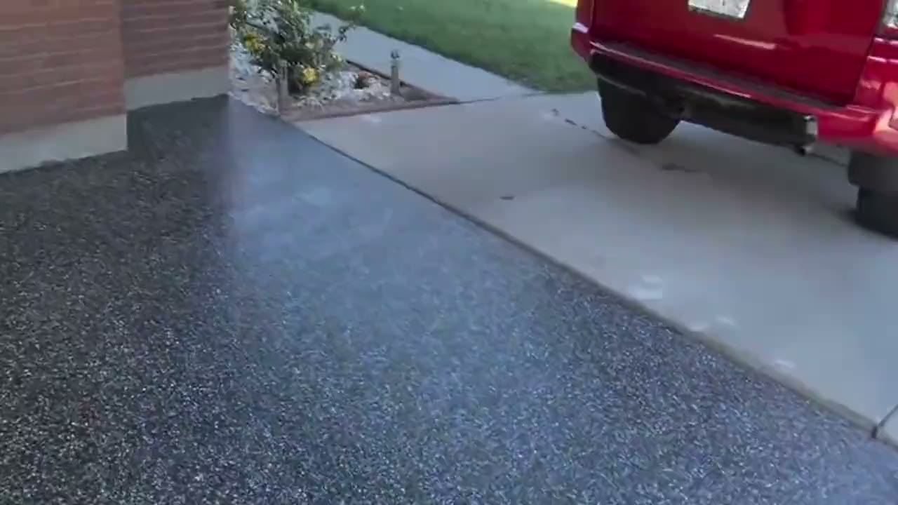 A finished flake carport floor running out to the driveway and the street beyond.