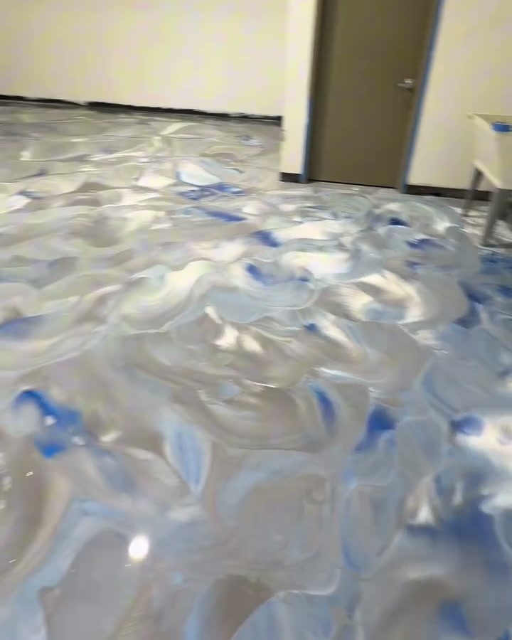 A garage floor finished in silver, white and blue metallic epoxy, poured and worked by hand.
